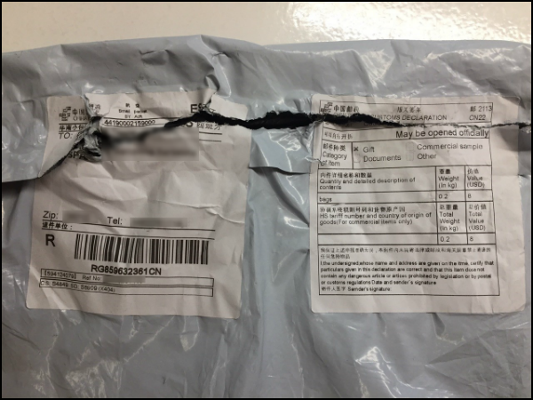Captura de pantalla del paquete recibido por nuestro protagonista donde se ven las etiquetas de precinto escritas en chino