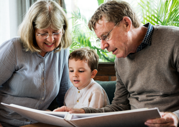 Imagen niño con abuelos leyendo libro
