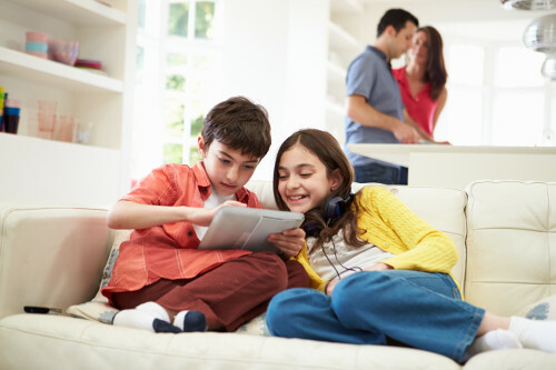 Niños utilizando en Internet en el salón con sus padres